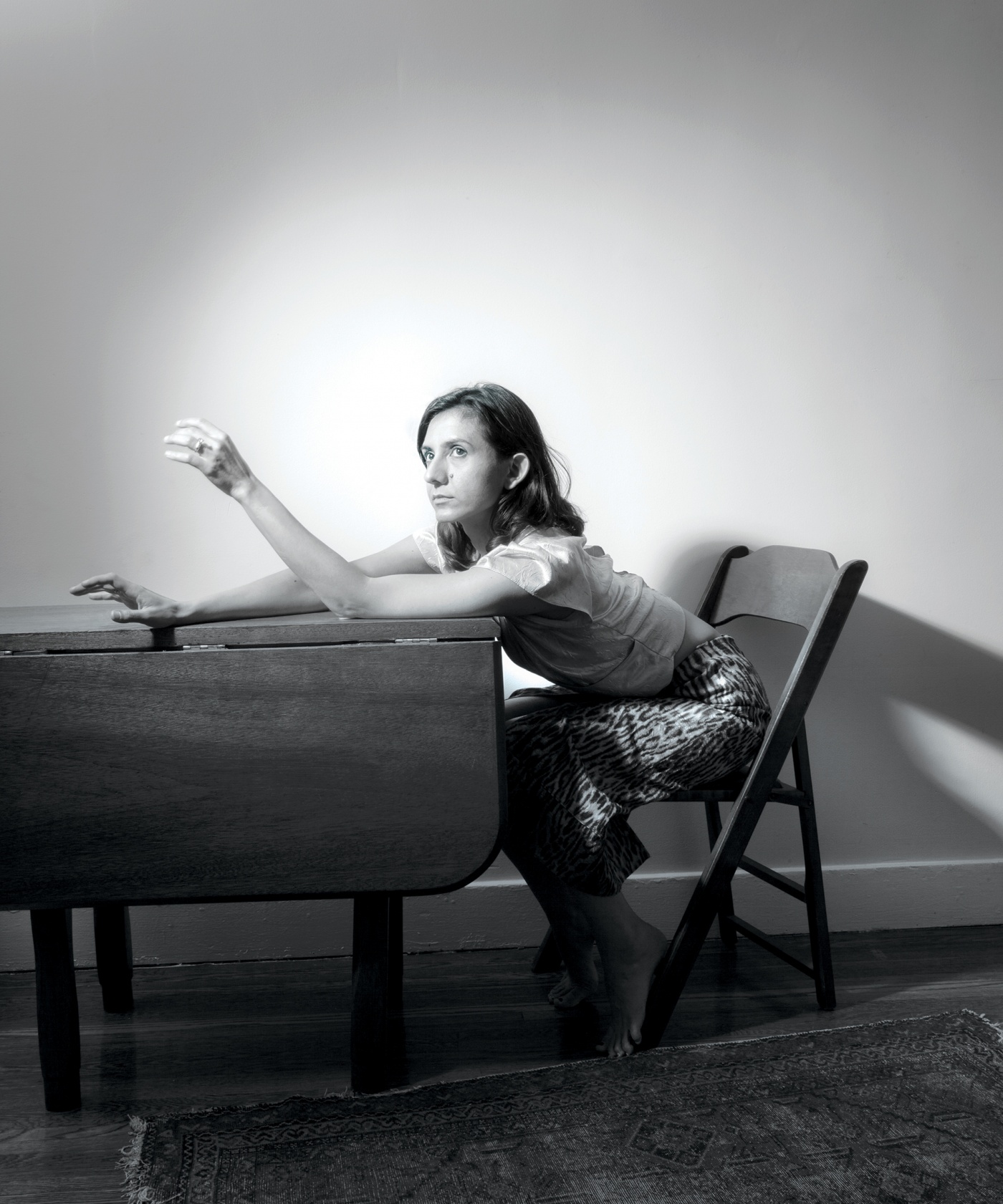 Black and white photograph of Ottessa Moshfegh &rsquo;11 sitting at a table